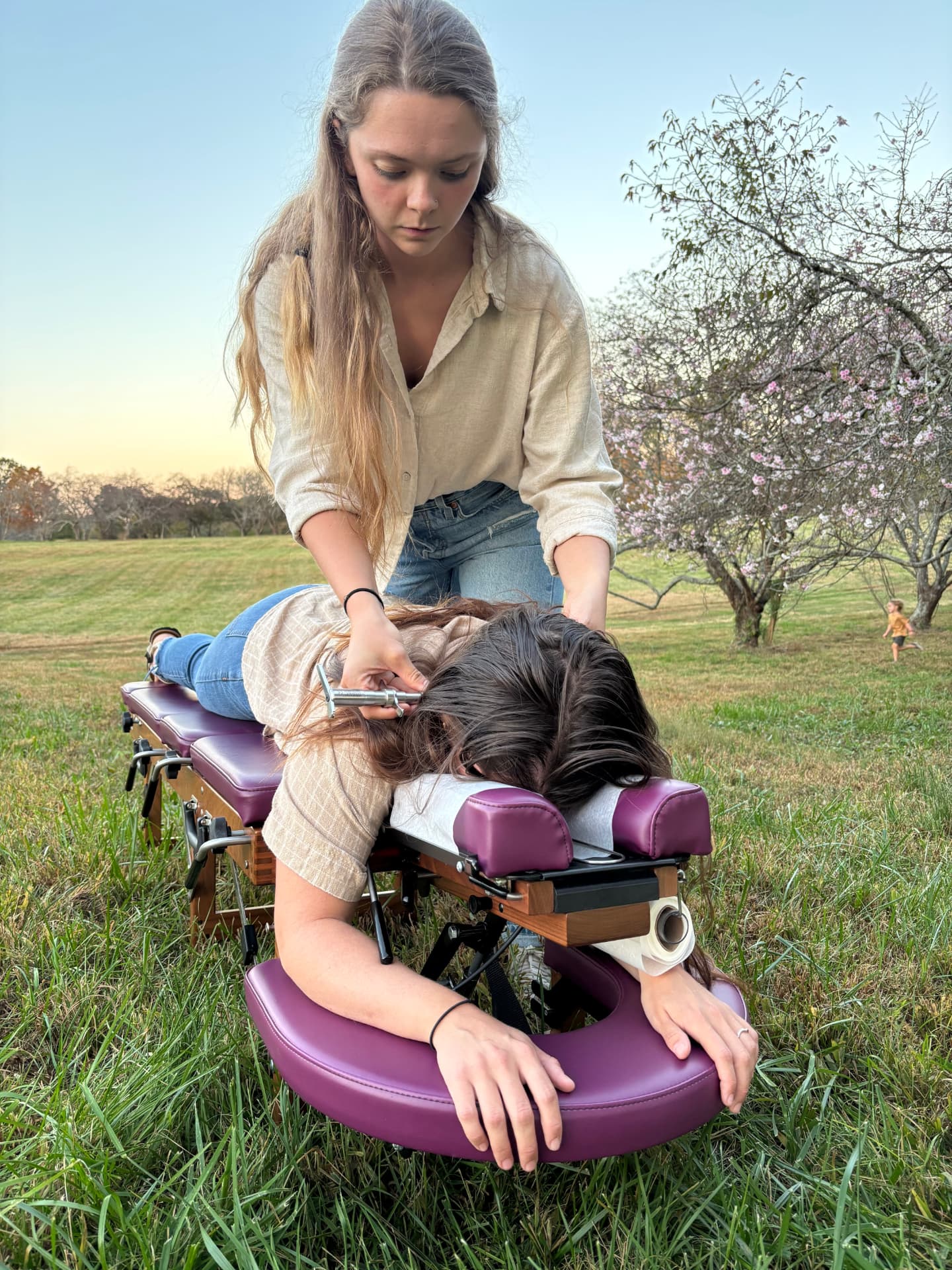 Dr. Shannon adjusting a woman on a chiropractic table at golden hour